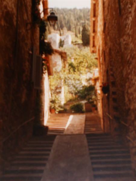 Stone alley with steps and lantern between old walls