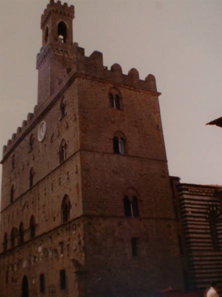 Palazzo dei Priori in Volterra, crenellated stone tower with clock