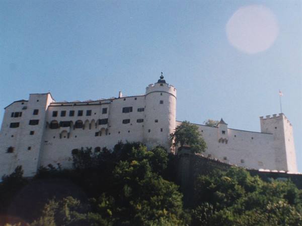 Hohensalzburg Fortress, white walls above green rock, sunny light