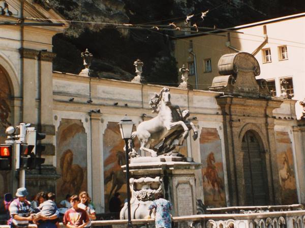 Tourists by the baroque horse fountain with frescoed wall, Salzburg