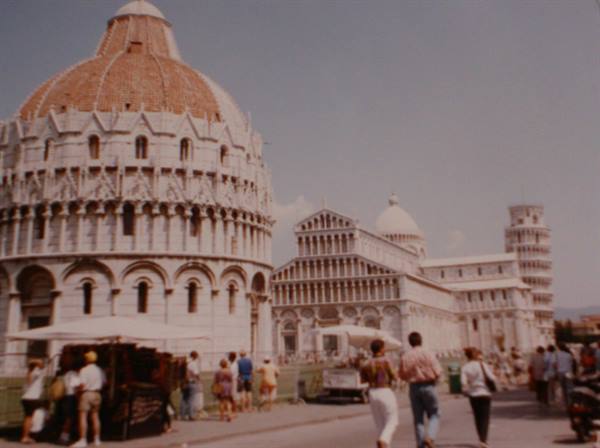 Tourists walk in Pisa's Piazza dei Miracoli, near the baptistery and the leaning tower