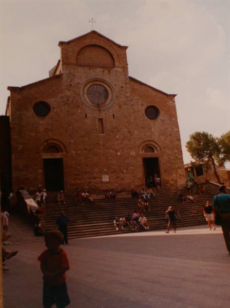 Tourists on the wide steps of the brick collegiate church, child in foreground