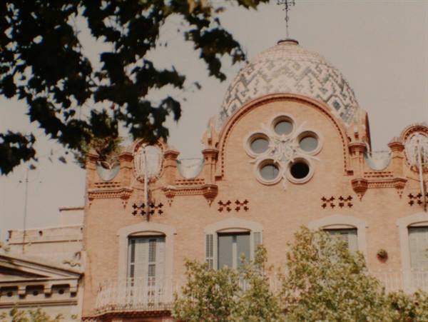 Brick modernist building facade with mosaic-tiled dome and circular windows