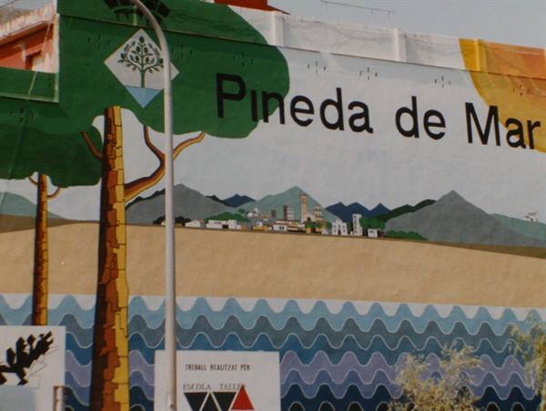 Mural in Pineda de Mar: painted trees, mountains and stylized waves