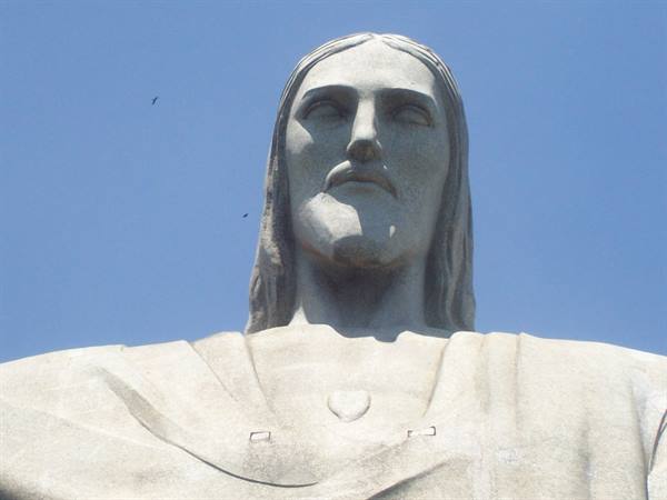 Face of Christ the Redeemer stone statue, Rio de Janeiro, sunlight against blue sky