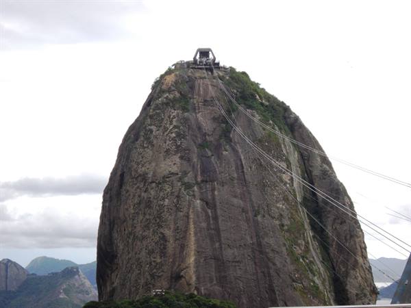 Cable car station atop Sugarloaf granite peak under cloudy sky in Rio