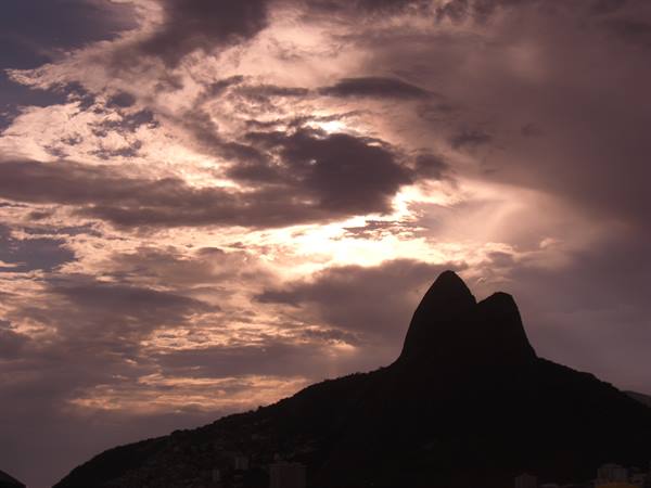 Twin peak of Dois Irmãoes silhouetted against pink clouds in Rio de Janeiro