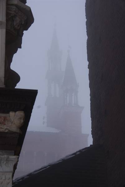Spires of Castello Sforzesco in the fog, framed by carved marble