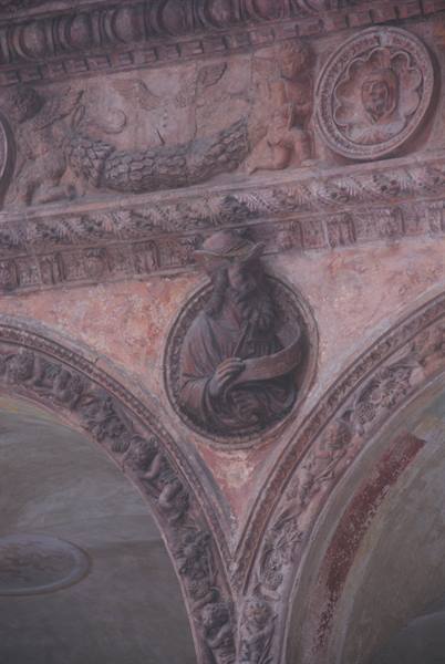 Carved prophet in a stone medallion between ornate arches, soft light