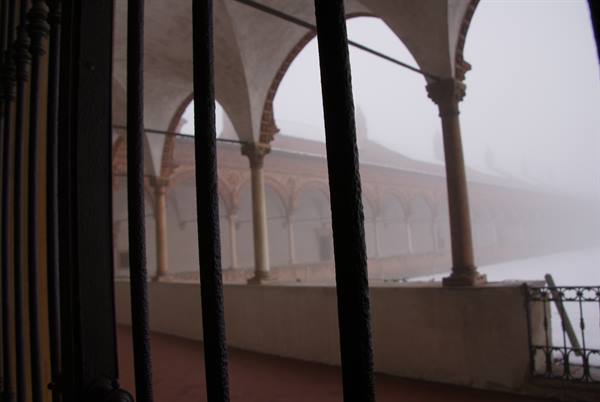 Brick cloister arches and columns veiled in fog, Certosa di Pavia