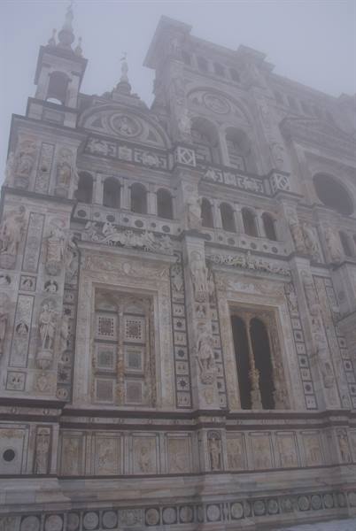 Marble facade of Certosa di Pavia shrouded in fog