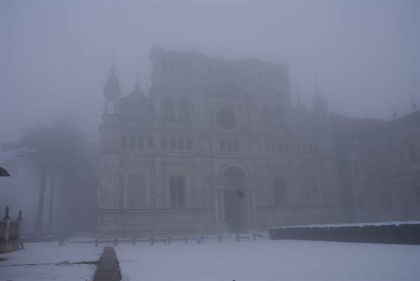 Certosa di Pavia in the fog, snowy marble facade, gray light