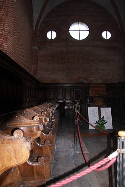 Carved wooden stalls in brick church with round windows