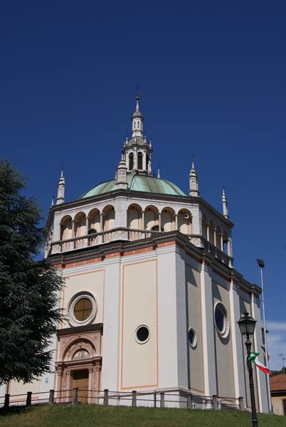 White church with greenish dome and spires, blue sky, grassy lawn