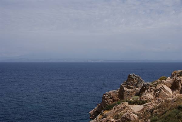 Granite rocks overlooking the open sea under a cloudy sky
