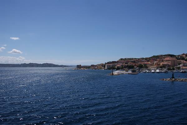 La Maddalena harbor: colorful waterfront houses, moored boats, deep blue sea