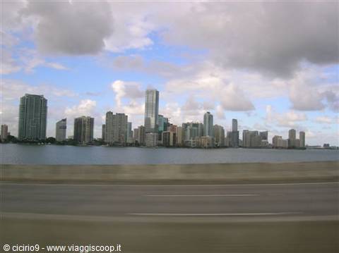 Miami skyscrapers across the bay, seen from the road under scattered clouds