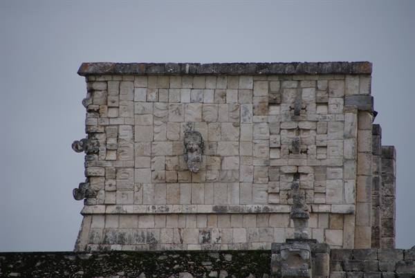 Carved stone figure on a Mayan temple at Chichén Itzá, grey sky