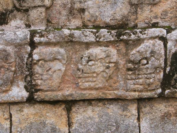 Carved stone skulls on the tzompantli wall at Chichén Itzá
