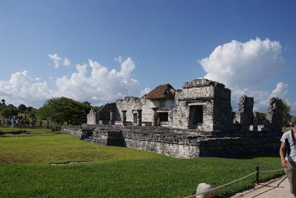 Tourists near the Maya ruins of Tulum under a cloudy sky