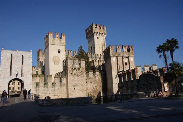 Scaligero Castle in Sirmione, crenellated stone walls and towers under blue sky
