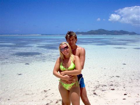 Couple in swimwear on white sand beach with turquoise shallow water