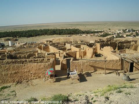 Tourist walking through the mud-brick ruins of an old desert village