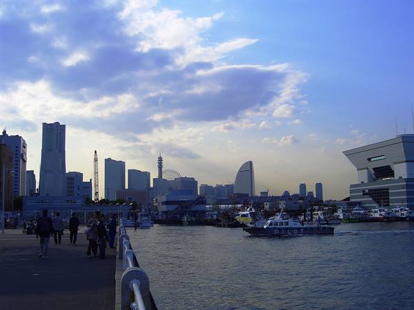 Ferry in Yokohama harbor, Minato Mirai skyscrapers under bright clouds