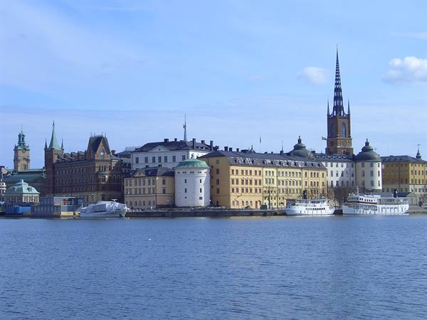 Riddarholmen in Stockholm: historic buildings, church spire, white ships moored on calm water