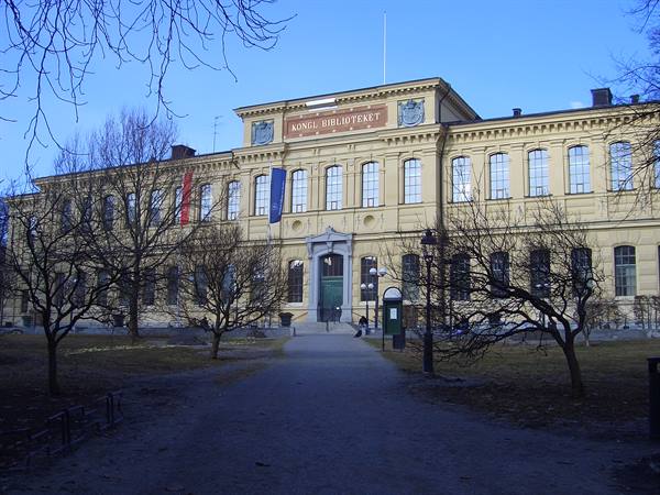 Yellow facade of Kungliga Biblioteket in Stockholm, bare trees, clear blue sky