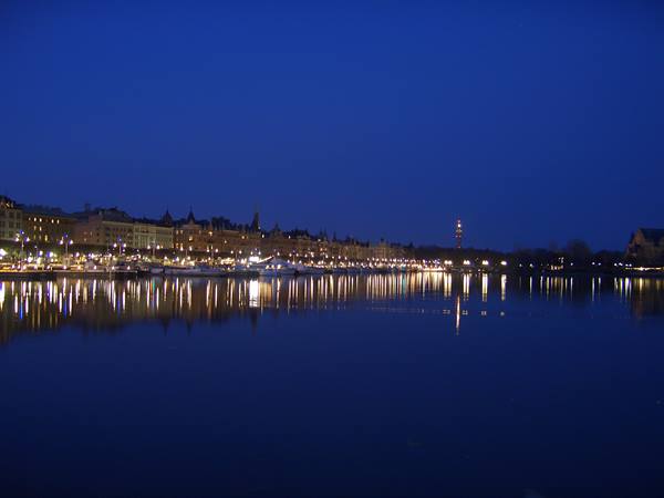 Stockholm waterfront lit at night, lights reflecting on calm water