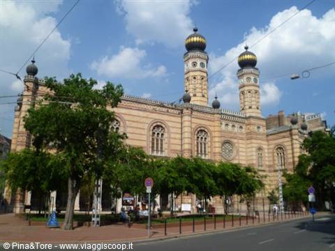 Dohány Synagogue in Budapest, golden domes among tram wires and green trees