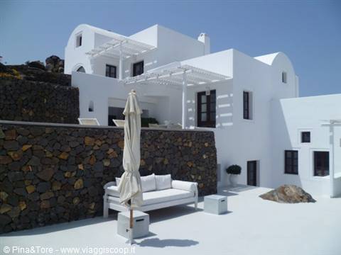 Terrace with white sofa and closed umbrella in front of Cycladic villa in Pyrgos