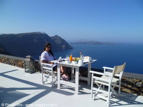 Breakfast on a white terrace in Imerovigli, set table overlooking the Aegean Sea