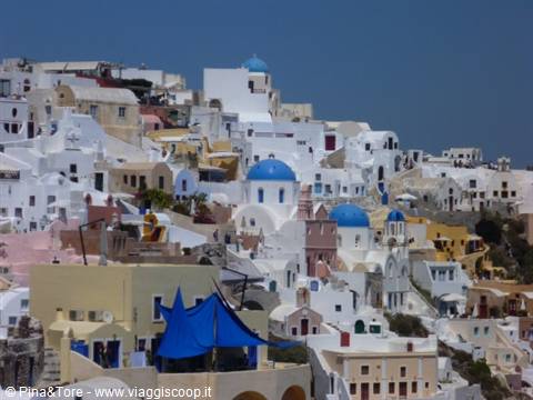 Blue domes and whitewashed houses of Oia under clear sky