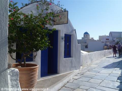 Oia: white house with blue door, bougainvillea pot and dome