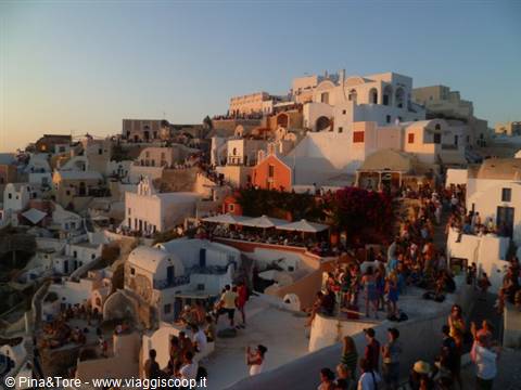 Crowd on Oia stairs among white houses at dusk