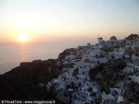 White houses and windmill in Oia as the sun sets over the Aegean
