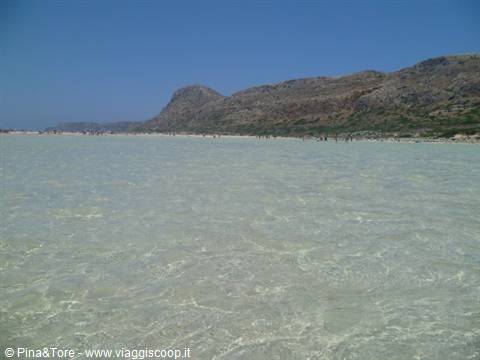 Balos lagoon, shallow turquoise water and arid mountains under blue sky