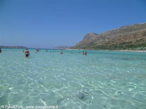 Bathers wading in the shallow turquoise lagoon of Balos, Crete