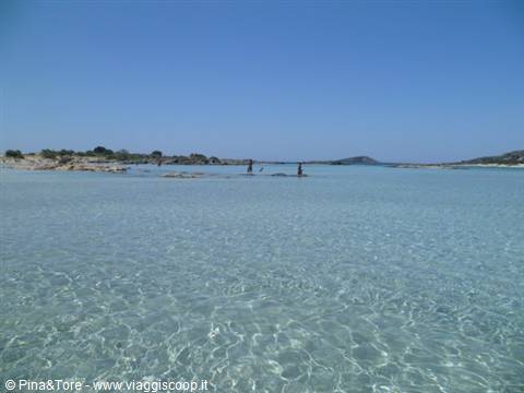 Shallow clear water at Elafonisi beach, people wading toward the islet
