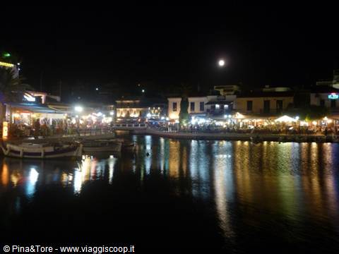 Chania old harbor at night, boats and lights reflecting on the water