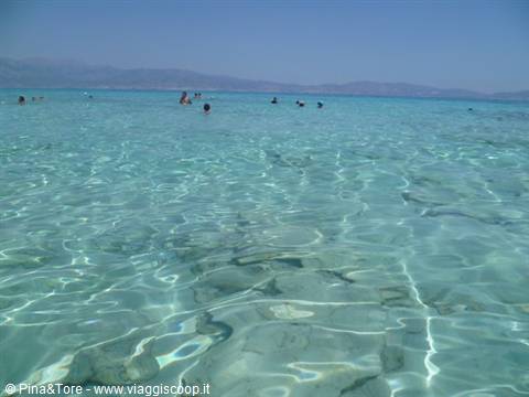 Swimmers in the clear turquoise shallows of Elafonisi, white sand seabed