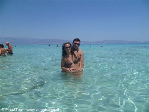 Couple standing in turquoise shallow water on a Cretan beach