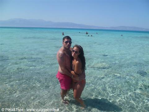 Couple embracing in the crystal-clear turquoise water of a Cretan beach