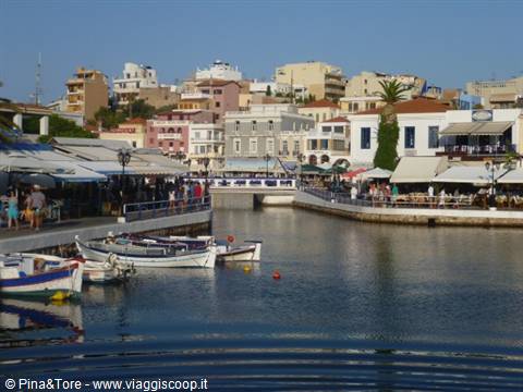Fishing boats at Agios Nikolaos harbor, cafés and colorful buildings