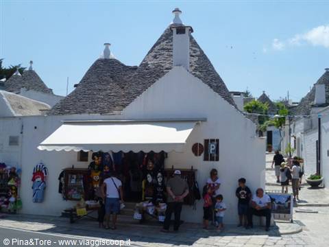 Tourists in front of a souvenir shop among the trulli of Alberobello