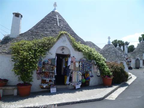 Trulli houses in Alberobello, stone roofs, souvenir shop in sunlight