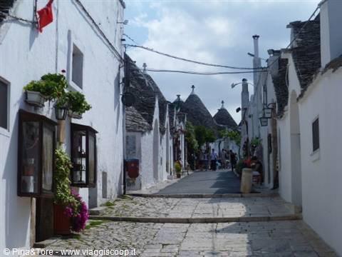 Cobbled street among the trulli of Alberobello, white walls and stone cone roofs