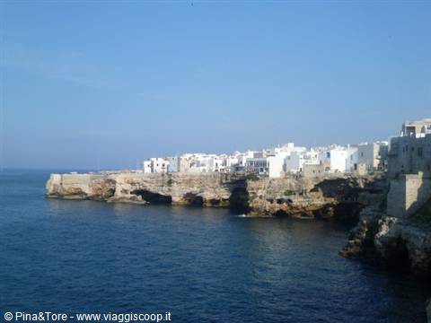 White houses on limestone cliffs overhanging the blue sea at Polignano a Mare